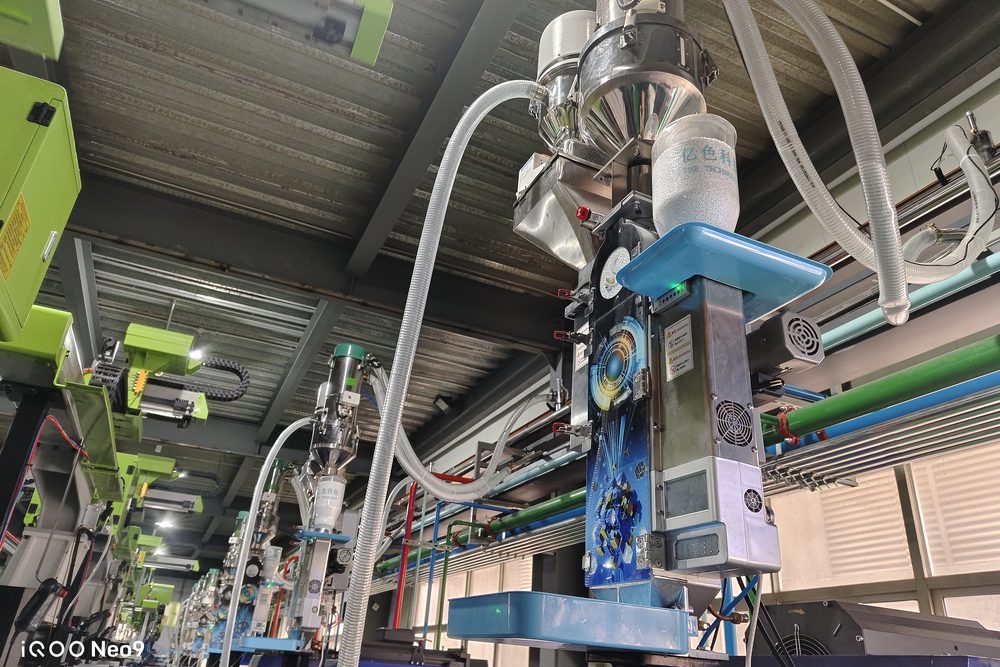 The unit above the hopper; the clear chamber lets an inspector read the powder level at a glance